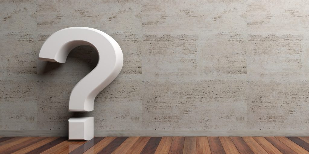 Question mark on wooden floor and marble wall background.