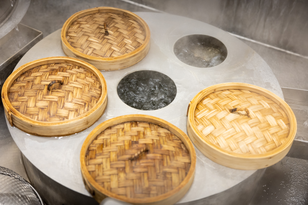 The wooden steam baskets that hold wontons steaming over the oven at The Noodle Den