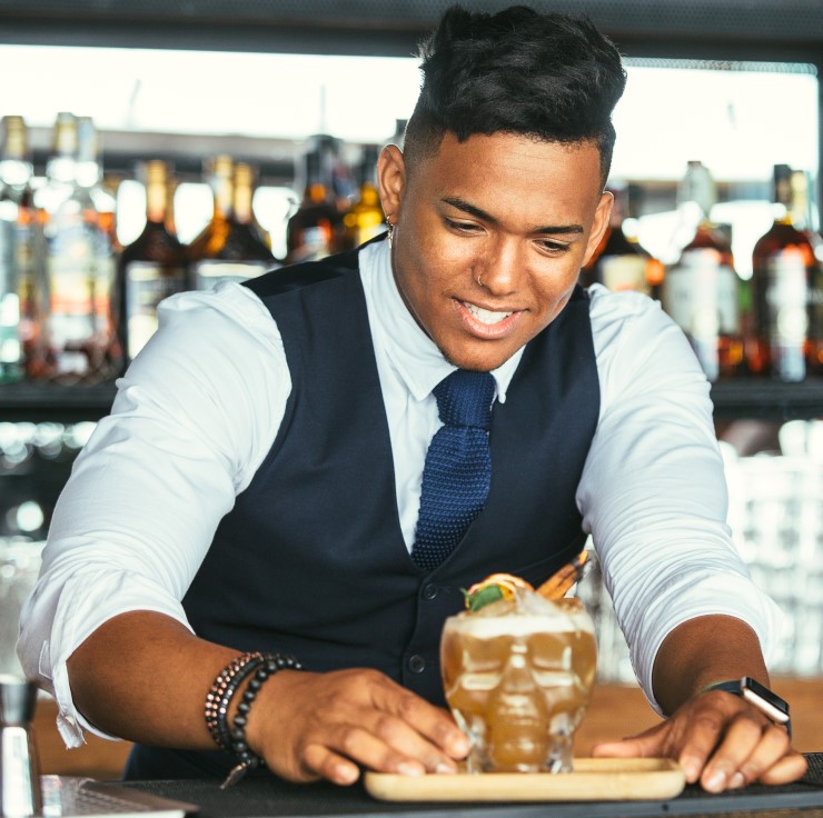 Smiling bartender presenting a cocktail