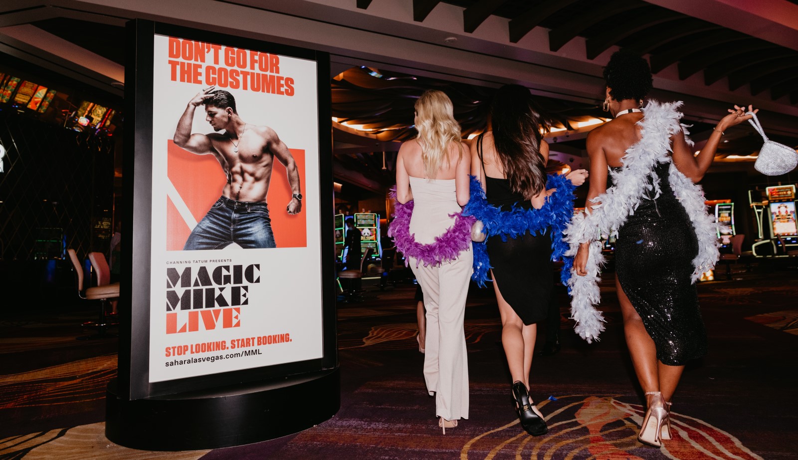 three ladies walking past a Magic Mike Live sign in a casino