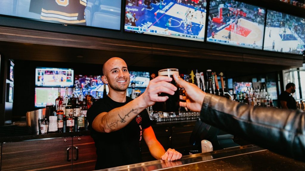 C&P Lifestyle shot of bartender handing a drink