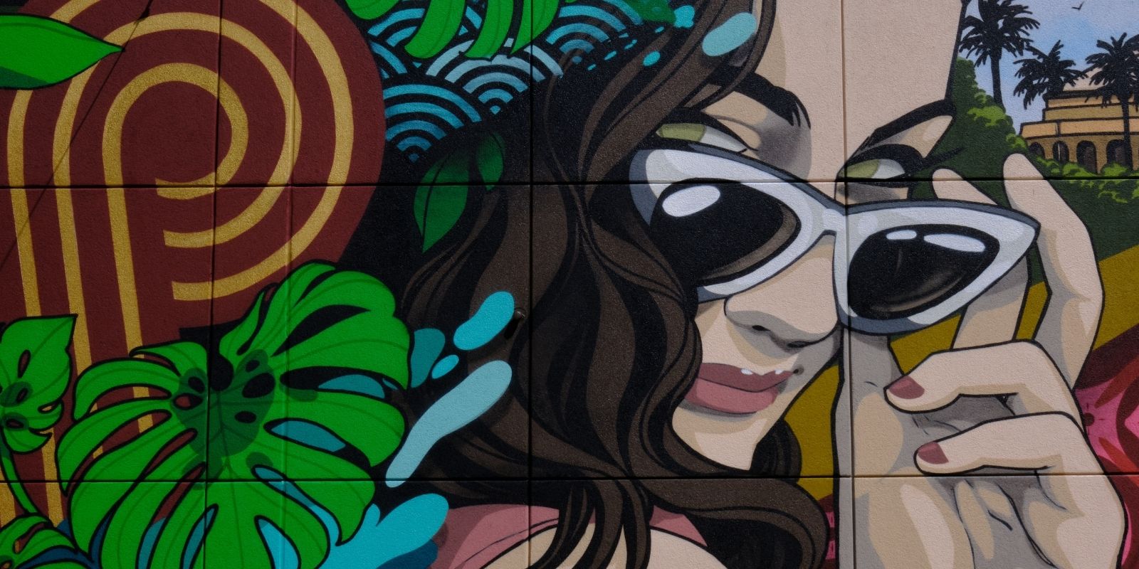 Mural art at the Retro Pool in SAHARA. Includes a woman peeking out above her sunglasses, leaves and the infinity S