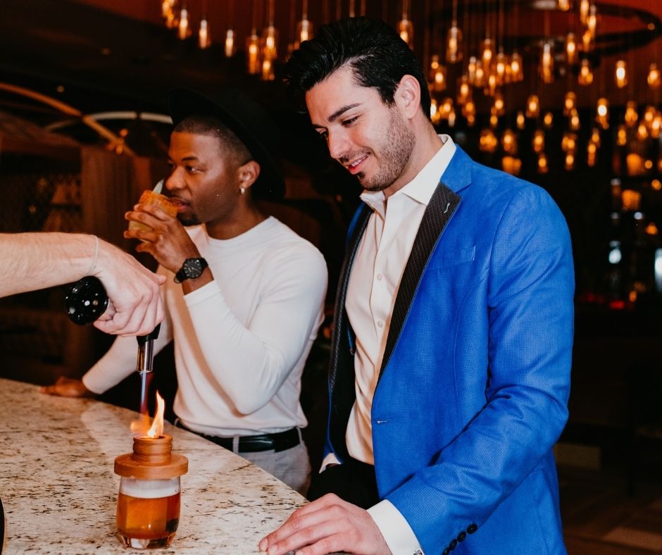 Two guys together at AZILO Lounge being served drinks