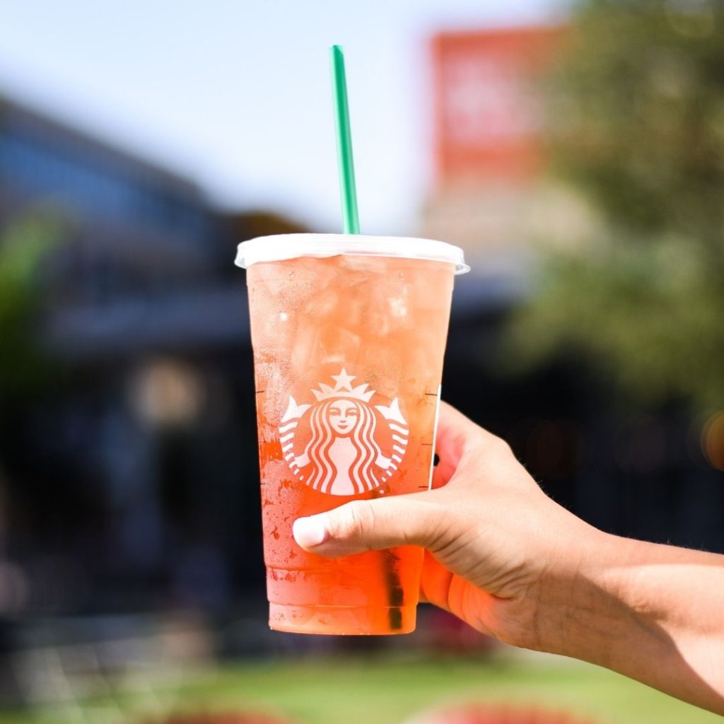 Starbucks iced tea being held by a hand outside