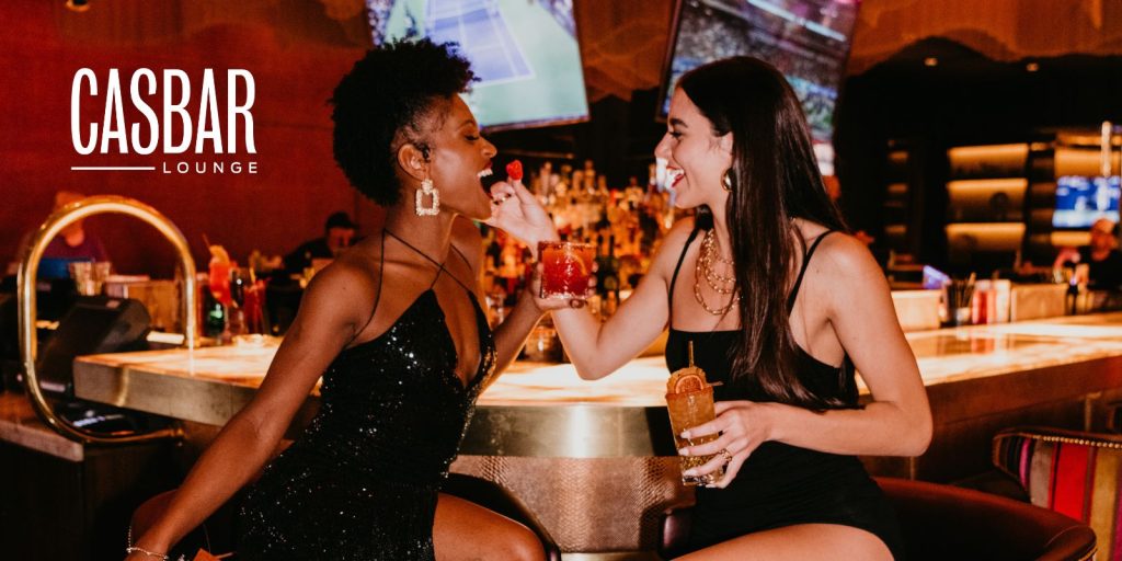 girls drinking at CASBAR Lounge laughing and having fun while showing off the entire lounge space
