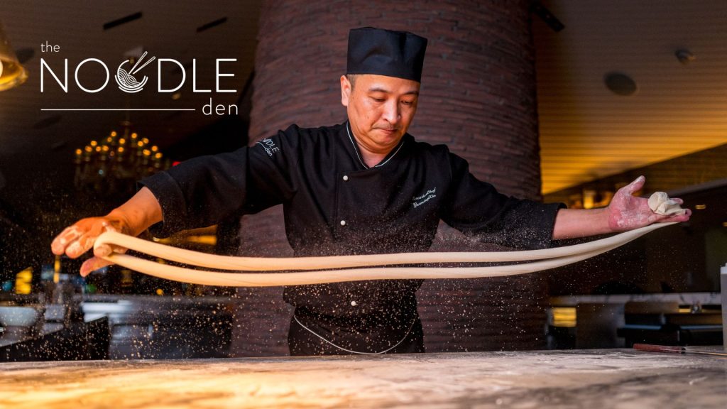 The Noodle Den hero shot showing the chef pulling noodles by hand