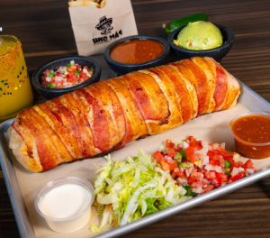National Burrito Day at Uno Mas - April 6, 2-pound Bacon wrapped burrito with sides of salsa, guacamole, and crema.
