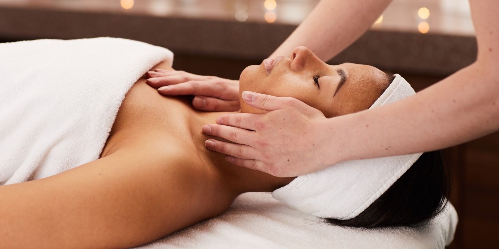 A woman getting a facial at amina spa. she is laying down with her eyes closed.