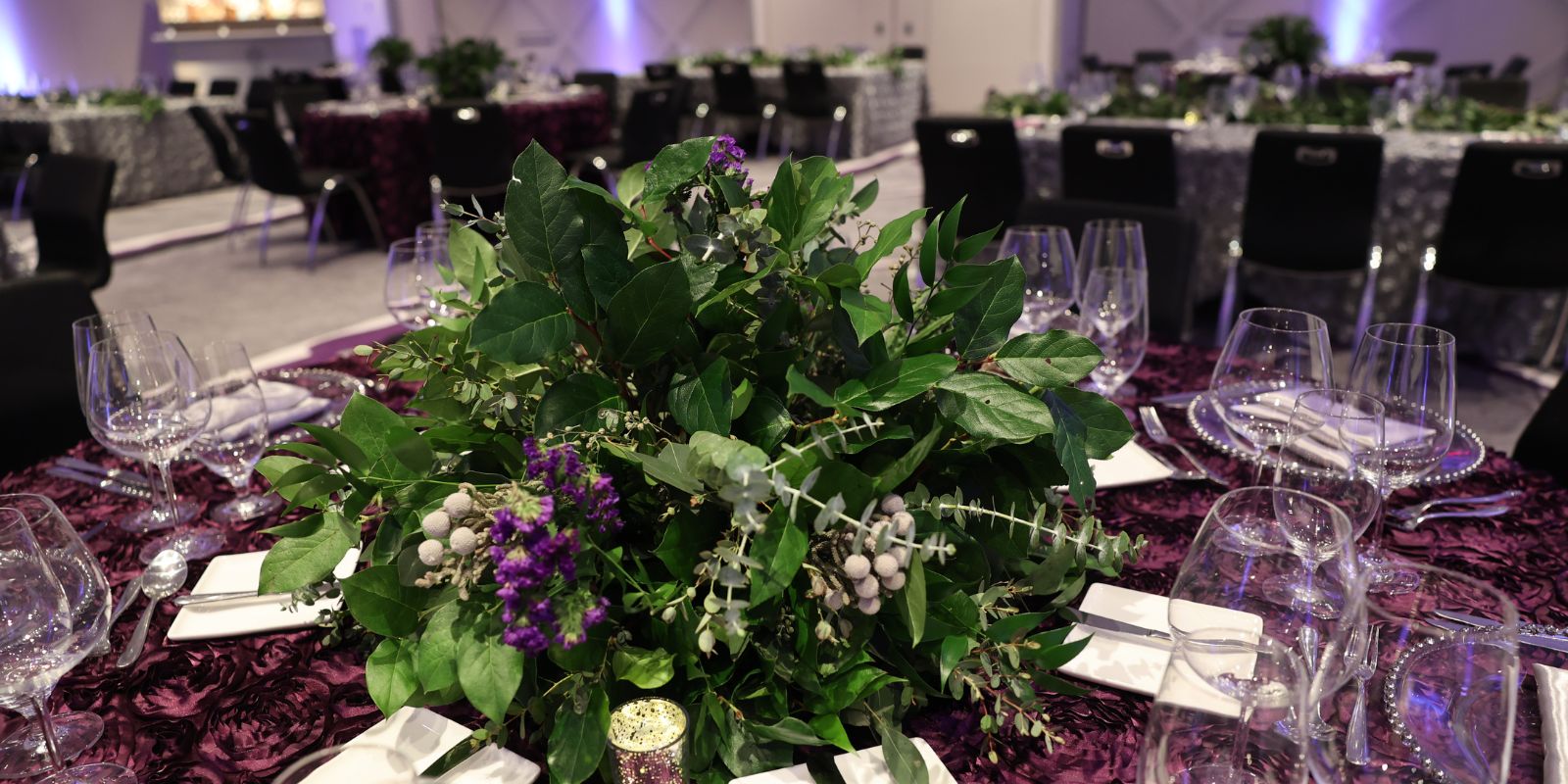 Catering and banquets set up within a meeting space showing floral arrangements and table settings.