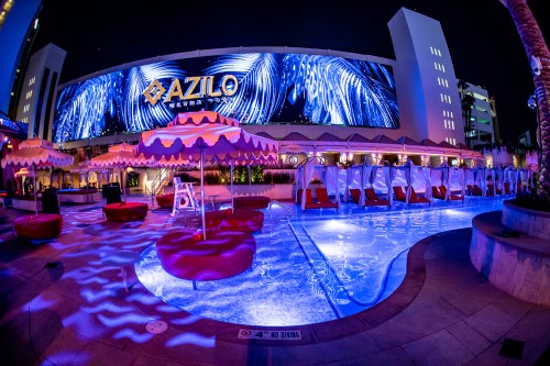 Nighttime shot of AZILO Ultra Pool with large video wall as feature