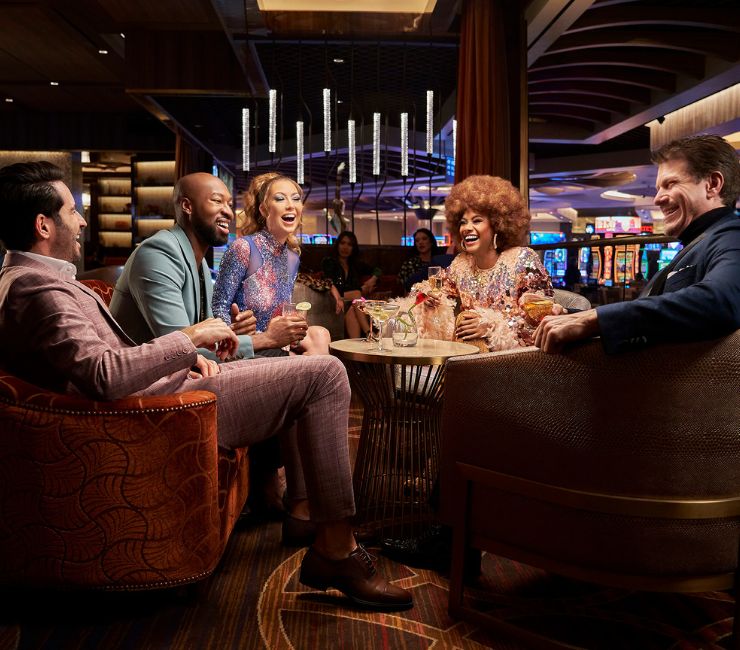 A group of friends laughing over drinks at CASBAR Lounge