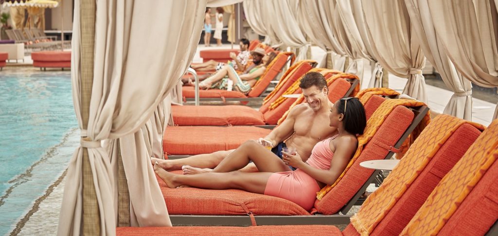 couple in the foreground in a daybed at AZILO Ultra Pool