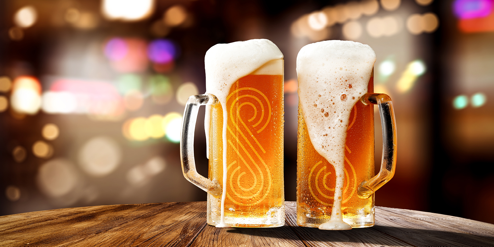 Two full beer glasses with the SAHARA logo etched into it